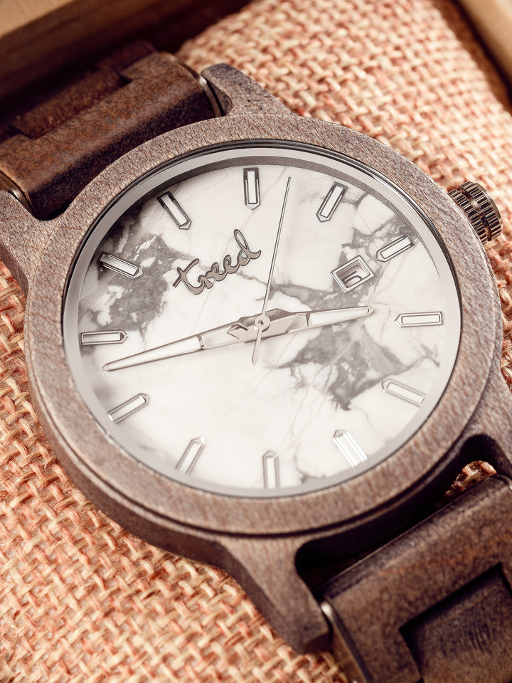 Close-up of Treed Alpine white marble dial with polished hands and indices