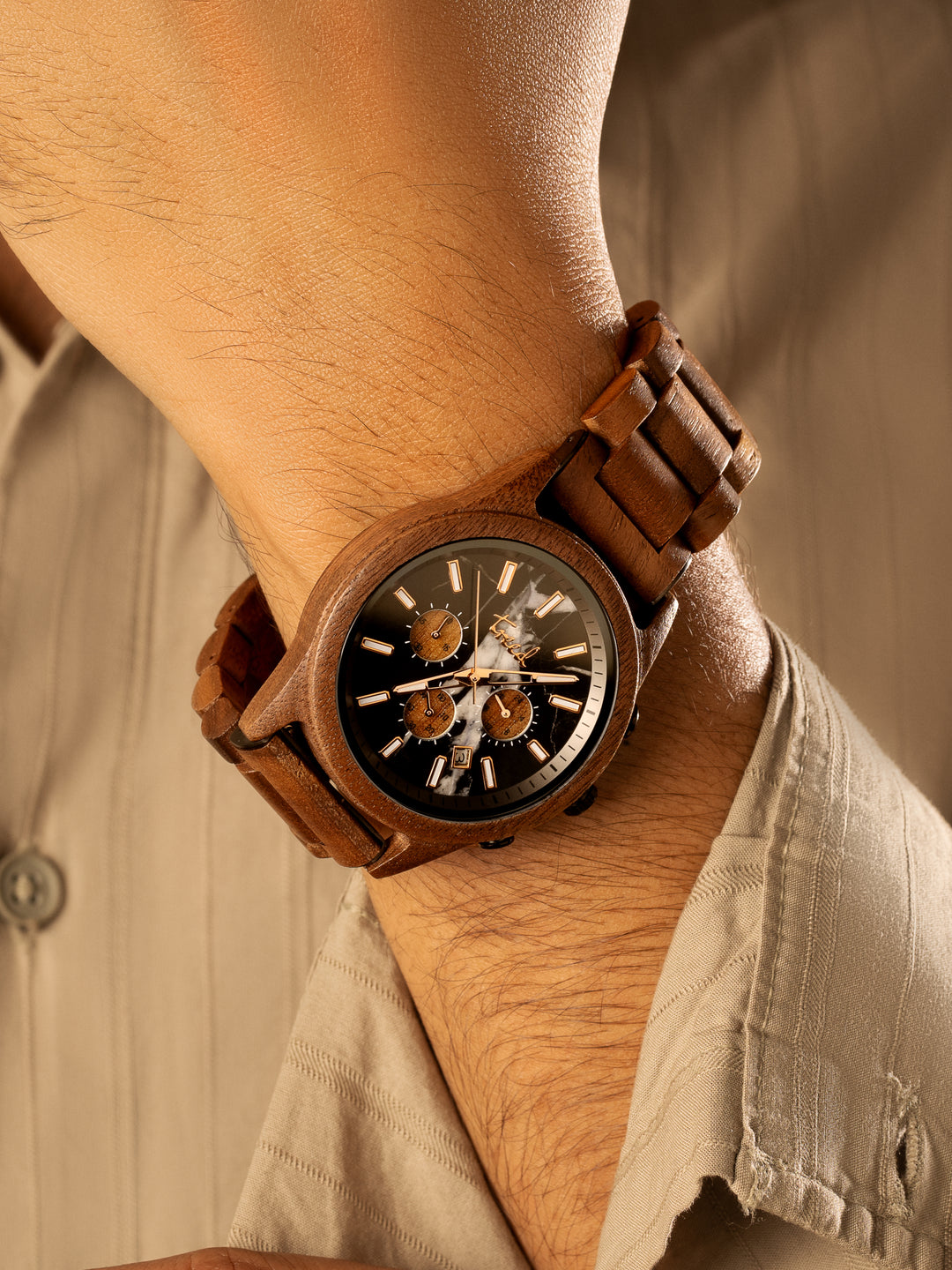 Walnut wooden chronograph watch with black marble dial worn on wrist